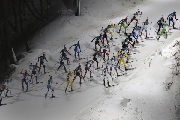 Biathlon skiers racing uphill
